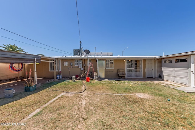 back of property featuring a lawn and an attached garage