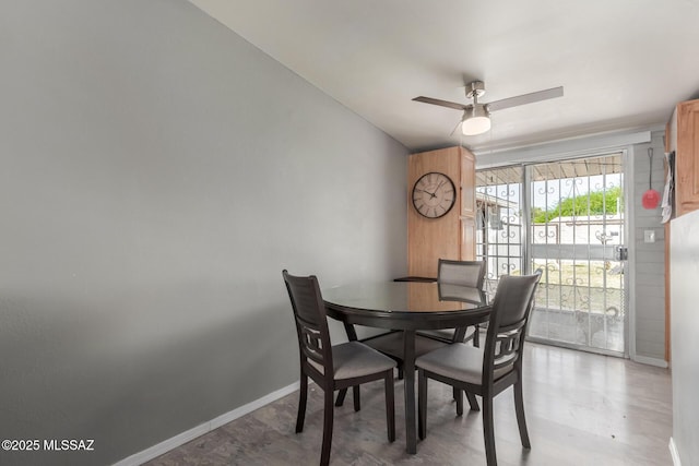 dining space with baseboards and ceiling fan