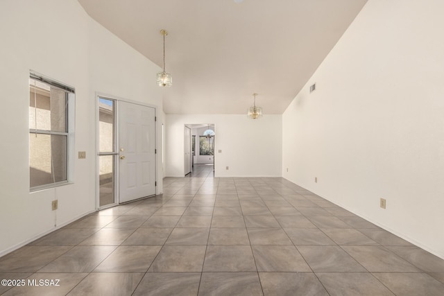 empty room featuring tile patterned flooring, visible vents, high vaulted ceiling, and a healthy amount of sunlight