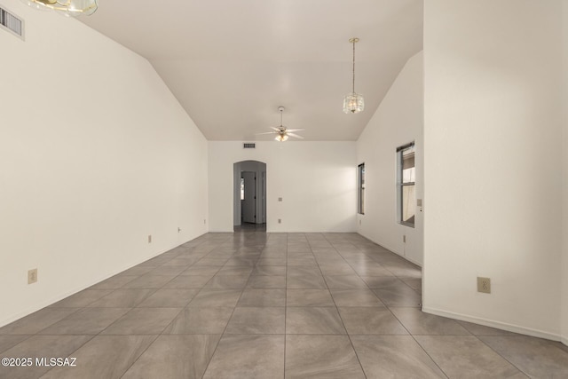 unfurnished room with high vaulted ceiling, arched walkways, a ceiling fan, and visible vents