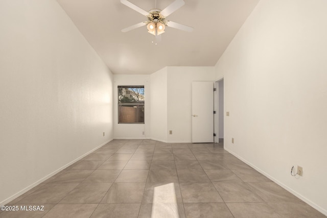 empty room featuring baseboards, vaulted ceiling, a ceiling fan, and light tile patterned floors