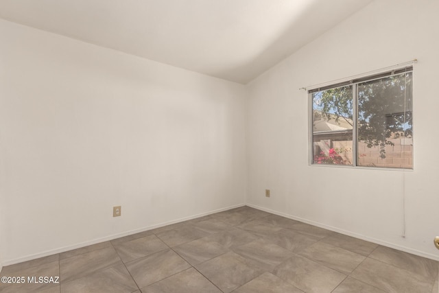 unfurnished room featuring vaulted ceiling and baseboards