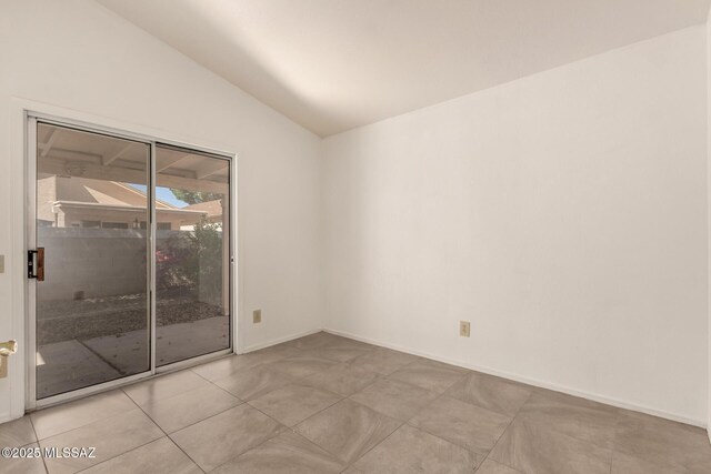 spare room featuring baseboards, lofted ceiling, and light tile patterned floors
