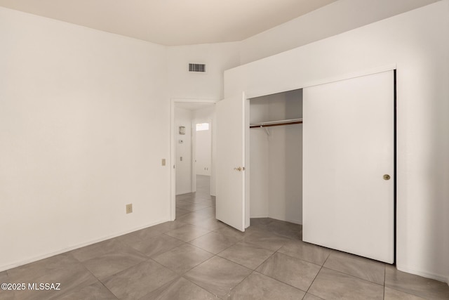 unfurnished bedroom with a closet, visible vents, baseboards, and light tile patterned floors