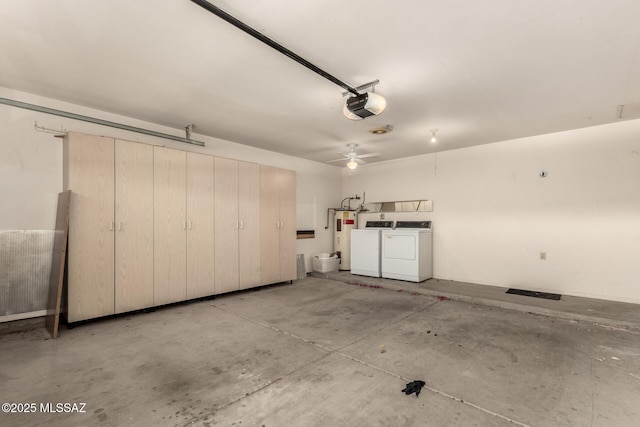 garage with washing machine and clothes dryer, water heater, and a garage door opener