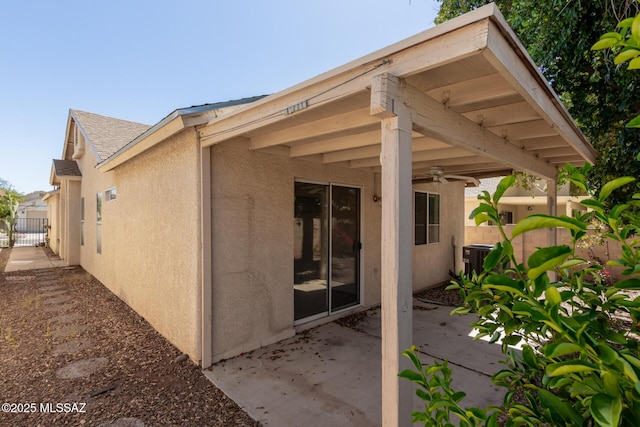 back of house featuring fence, a patio area, central AC, and stucco siding