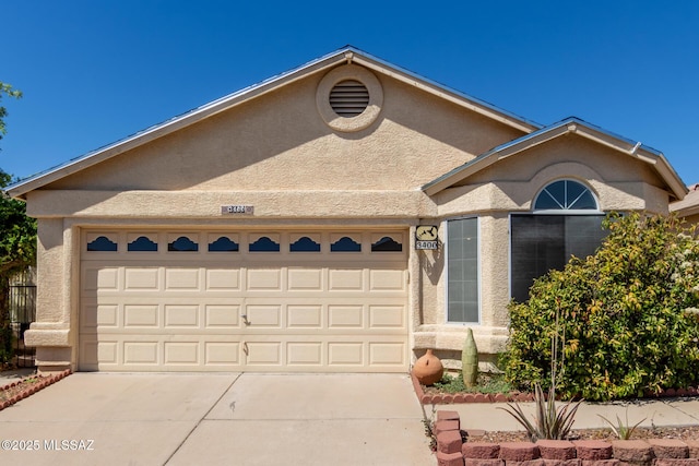 single story home with a garage, concrete driveway, and stucco siding