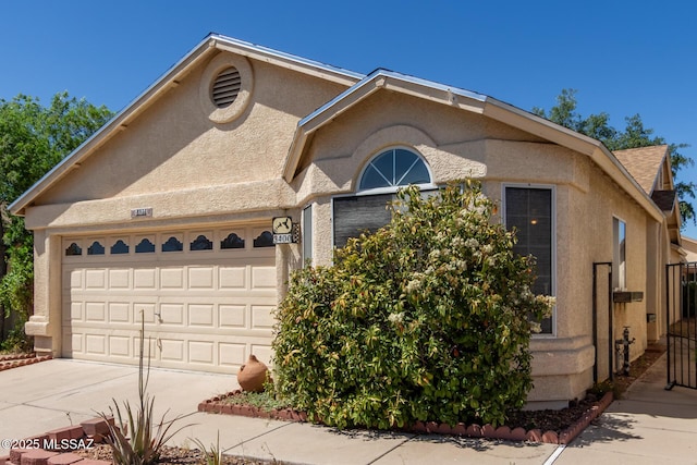 view of front of house featuring stucco siding, driveway, and a garage