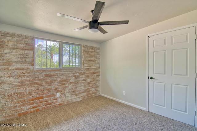 5754 S Ray Stra, Tucson, AZ 85706 - empty room with baseboards, a ceiling fan, carpet floors, and brick wall