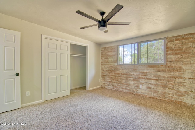 5754 S Ray Stra, Tucson, AZ 85706 - unfurnished bedroom with brick wall, a closet, a ceiling fan, baseboards, and carpet floors