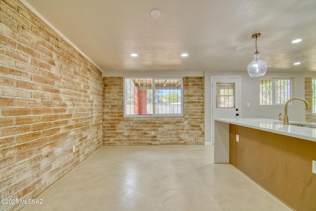 5754 S Ray Stra, Tucson, AZ 85706 - kitchen featuring recessed lighting, hanging light fixtures, a sink, and brick wall