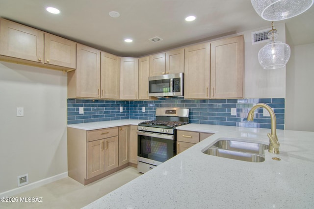 5754 S Ray Stra, Tucson, AZ 85706 - kitchen with light brown cabinetry, light stone counters, appliances with stainless steel finishes, and a sink