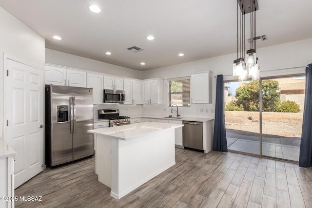 kitchen featuring visible vents, a sink, light wood-style floors, appliances with stainless steel finishes, and white cabinetry