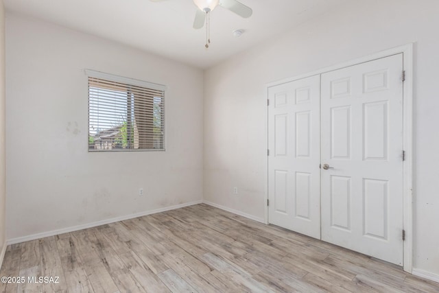 unfurnished bedroom featuring light wood-style floors, a closet, and baseboards