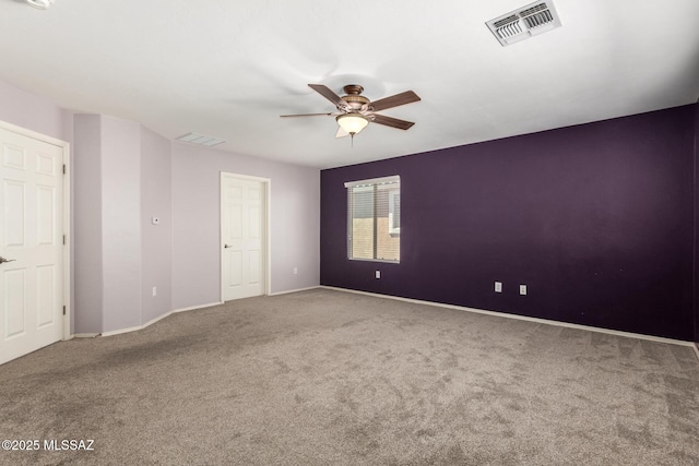 carpeted empty room featuring baseboards, visible vents, and ceiling fan