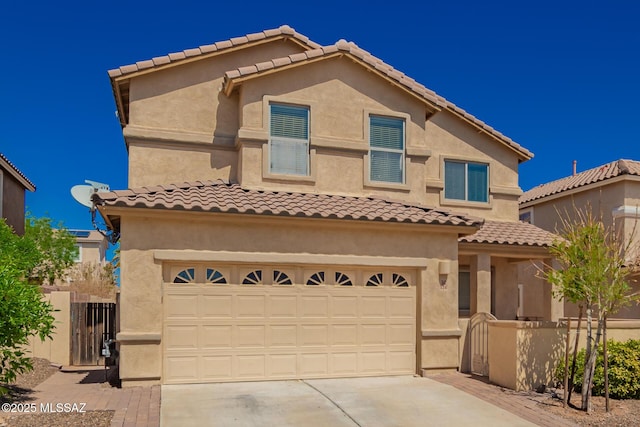 view of front of home featuring concrete driveway, a tiled roof, fence, a garage, and stucco siding