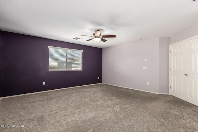 spare room featuring visible vents, carpet flooring, baseboards, and ceiling fan