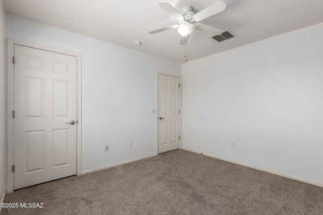 interior space featuring baseboards, a ceiling fan, carpet flooring, and visible vents