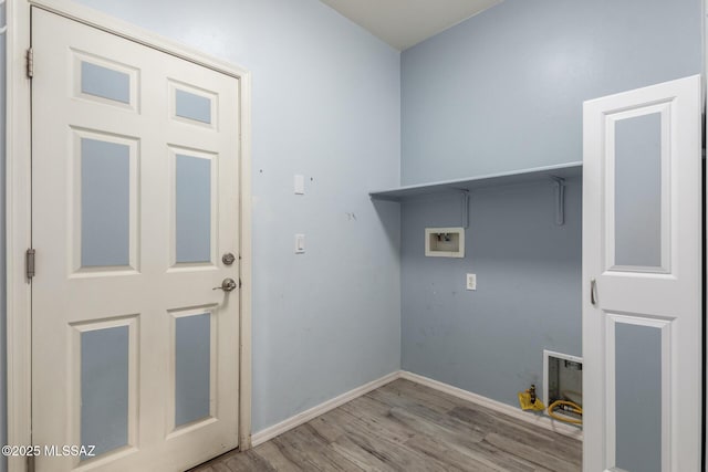laundry area with wood finished floors, hookup for a washing machine, baseboards, and laundry area