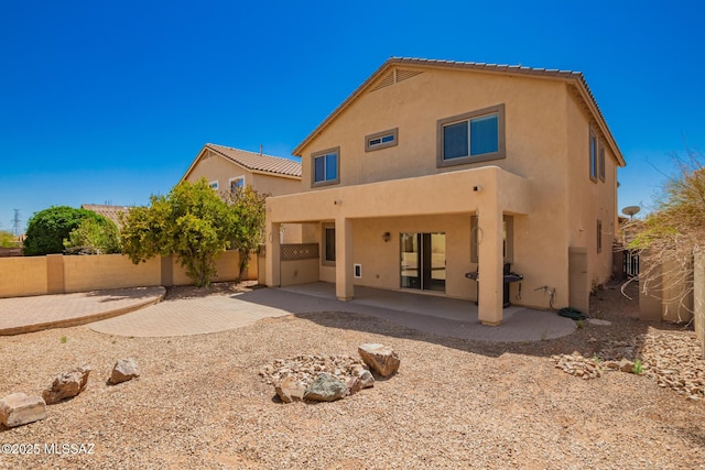 back of property with a patio area, a fenced backyard, and stucco siding