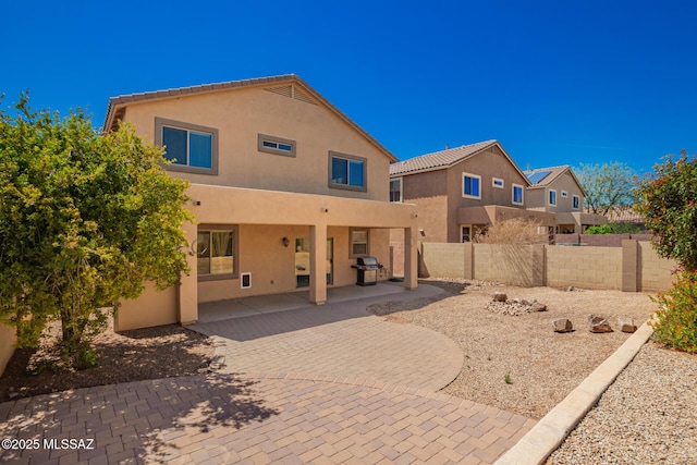 back of property featuring a patio, stucco siding, and fence