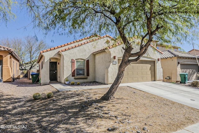 mediterranean / spanish home featuring an attached garage, a tiled roof, stucco siding, and driveway