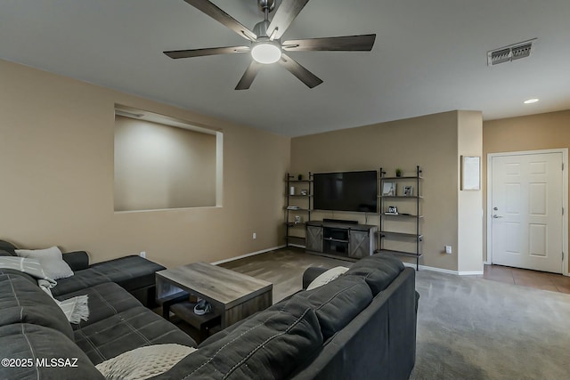 living room featuring baseboards, a ceiling fan, visible vents, and carpet floors