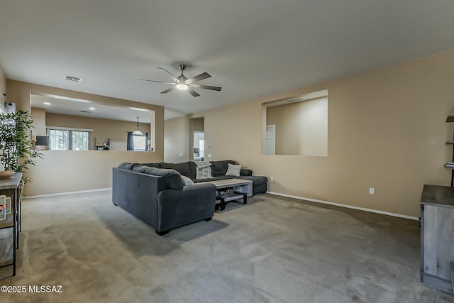 living area with carpet floors, visible vents, a ceiling fan, and baseboards