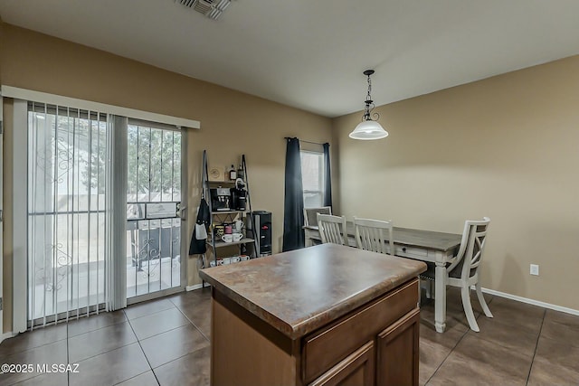 dining space featuring visible vents, baseboards, and dark tile patterned flooring