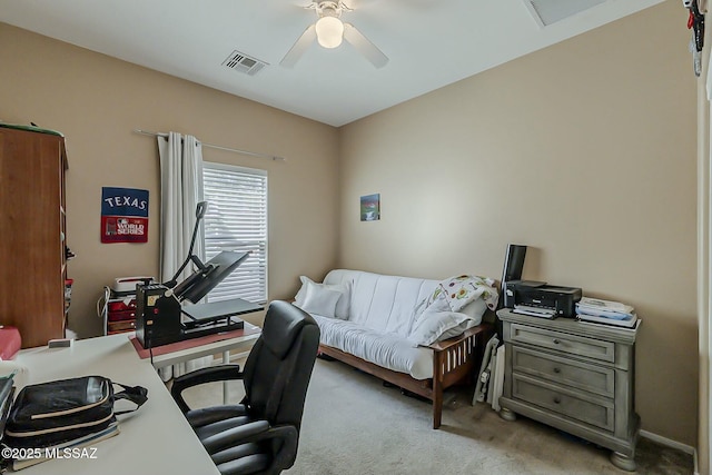 office area with a ceiling fan, visible vents, and light colored carpet