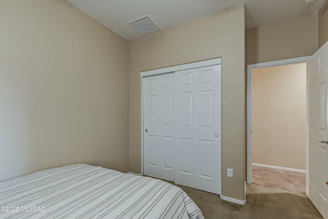 carpeted bedroom with a closet and visible vents