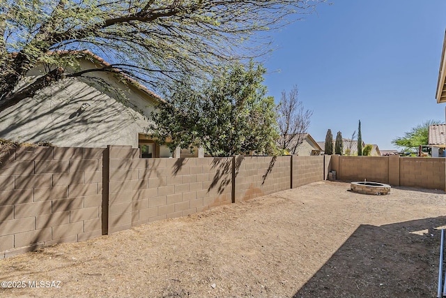 view of yard with a fenced backyard and an outdoor fire pit