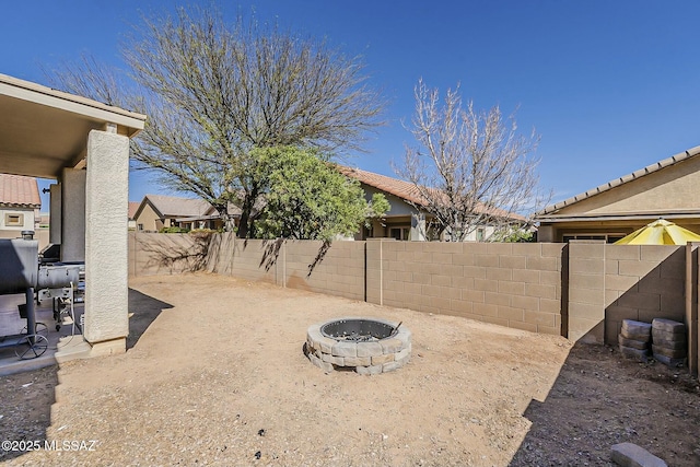 view of yard with a fire pit, a patio area, and a fenced backyard