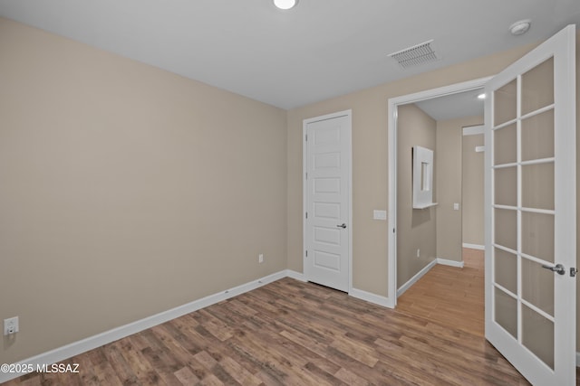 unfurnished bedroom featuring baseboards, wood finished floors, visible vents, and recessed lighting