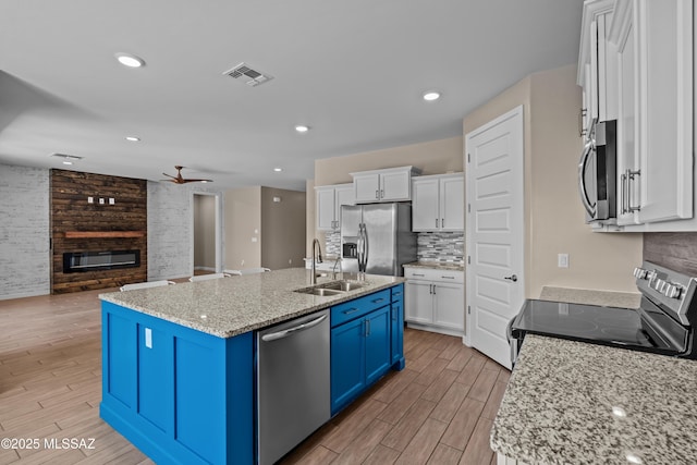 kitchen featuring blue cabinets, white cabinets, visible vents, ceiling fan, and appliances with stainless steel finishes
