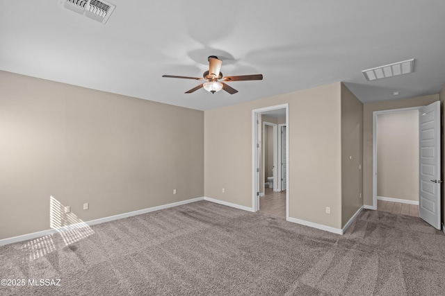 interior space with baseboards, a ceiling fan, visible vents, and carpet flooring