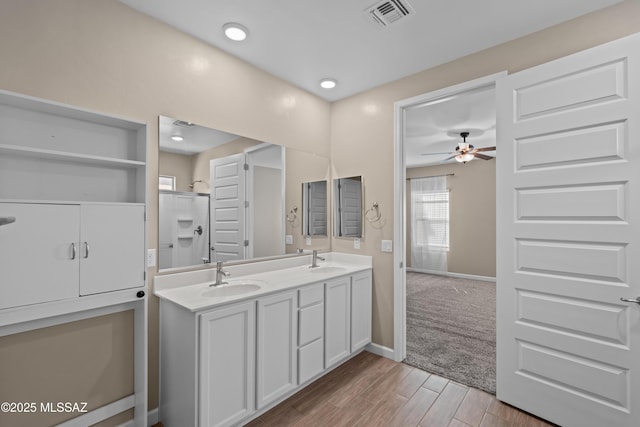 full bathroom with wood finished floors, a ceiling fan, visible vents, and a sink