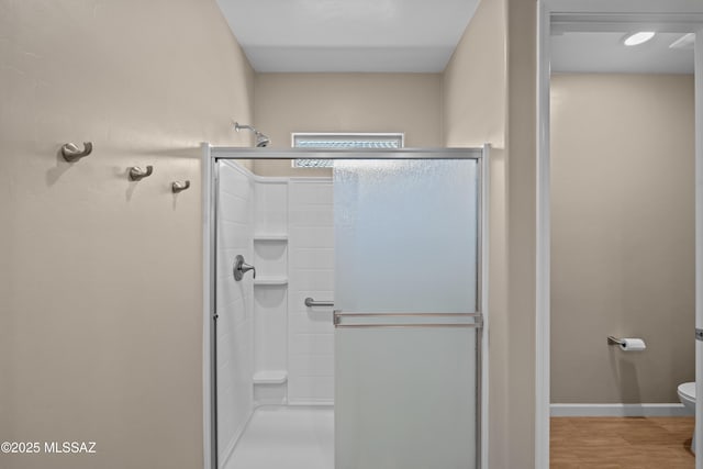 full bathroom featuring a shower stall, toilet, and baseboards