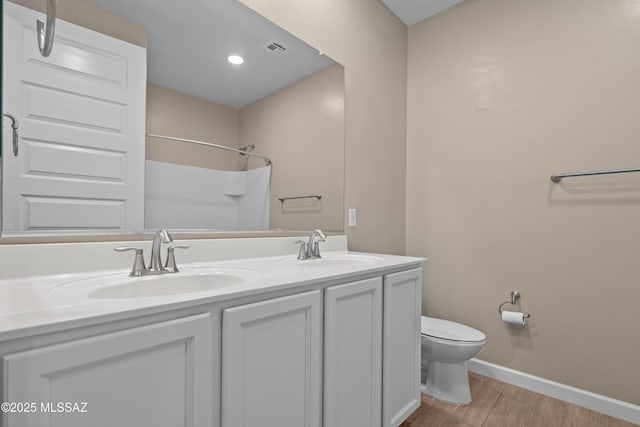 full bath with toilet, wood finished floors, a sink, and visible vents