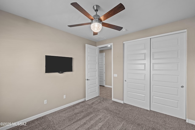 unfurnished bedroom with carpet, a closet, baseboards, and ceiling fan