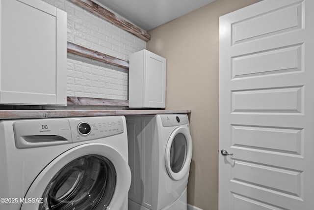 clothes washing area featuring cabinet space and washer and dryer