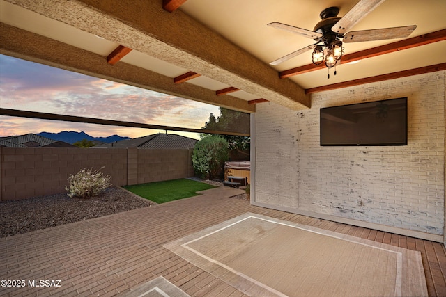 view of patio with ceiling fan, a fenced backyard, and a hot tub