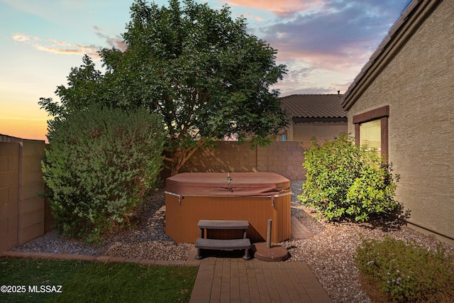 view of yard featuring fence and a hot tub