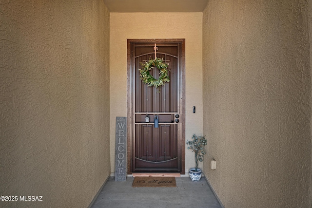 doorway to property featuring stucco siding