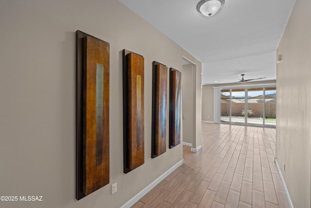 hallway featuring baseboards and wood finished floors