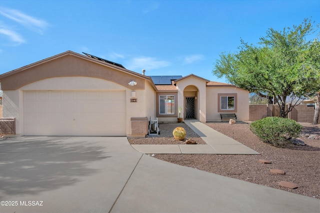 2145 N Horseshoe Trl, Tucson, AZ 85745 - view of front of house featuring stucco siding, a garage, solar panels, and driveway