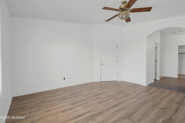 2145 N Horseshoe Trl, Tucson, AZ 85745 - empty room with arched walkways, ceiling fan, and wood finished floors