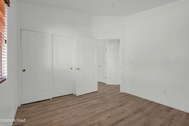 2145 N Horseshoe Trl, Tucson, AZ 85745 - unfurnished bedroom with wood finished floors, a closet, and baseboards