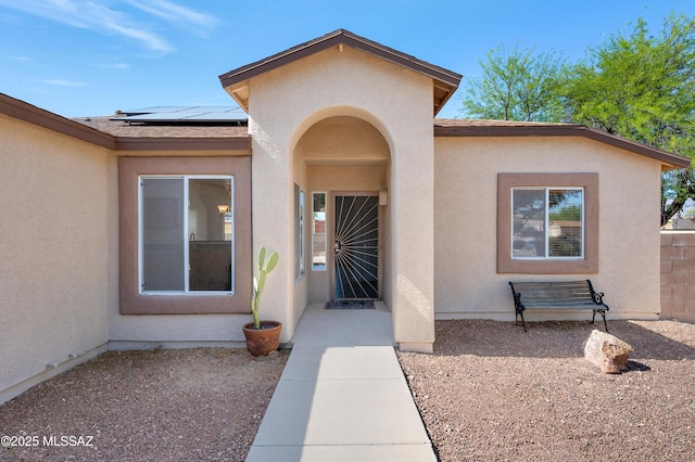 2145 N Horseshoe Trl, Tucson, AZ 85745 - view of exterior entry featuring solar panels and stucco siding