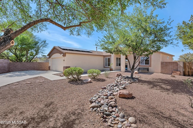 2145 N Horseshoe Trl, Tucson, AZ 85745 - view of front of property featuring stucco siding, driveway, solar panels, an attached garage, and a fenced backyard